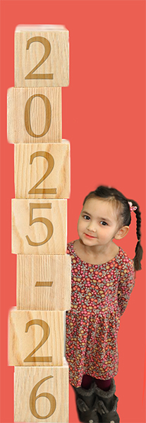 A preschool child leaning on blocks with "2025 - 26" on them with a pink backround